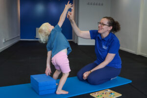 Paediatric physio assessing a toddlers' ability to balance and reach