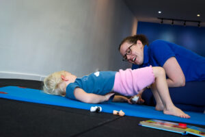 Paediatric Physiotherapy and a toddler lifting her body off the groudn